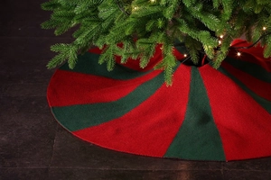 Detailed view of red and green knitted Christmas tree skirt with festive striped pattern
