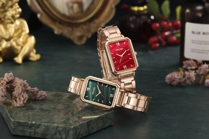 Detail of luxury rectangular emerald and ruby dials on rose gold mesh strap watches