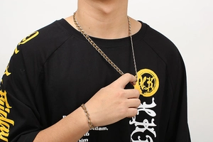 Close-up of model wearing two-tone gold and silver stainless steel chain jewelry set