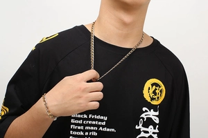 Detailed close-up of 8mm stainless steel embossed chain necklace and bracelet on model