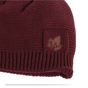 Detailed close-up of dark red knit beanie featuring a brown leather maple leaf patch