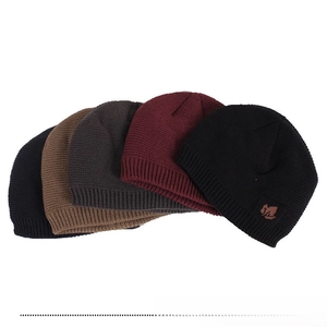 Detail view of multicolored knit beanies featuring maple leaf patch and ribbed cuff texture