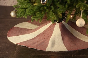 Close-up of red and beige knitted Christmas tree skirt with festive stripe textures