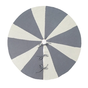 Detail of grey and white knitted Christmas tree skirt with secure tie closures