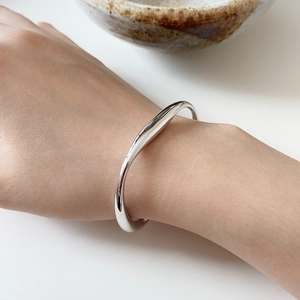 Minimalist 925 sterling silver cuff bracelet with an irregular streamlined polished design