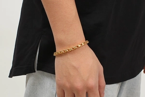 Close-up of gold-plated stainless steel linked chain bracelet worn on a man's wrist