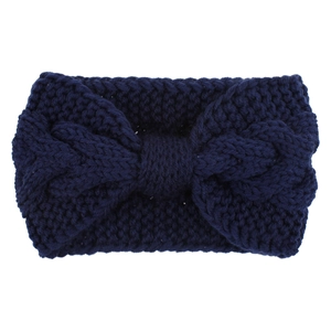 Close-up of deep blue cable knit headband showing twisted weave texture and knot detail