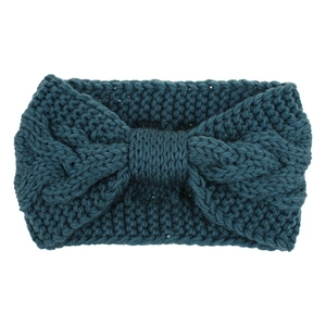Macro detail of teal cable knit headband showing rich texture and decorative bow