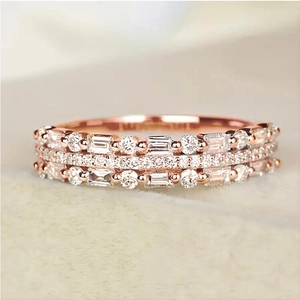 Macro shot of rose gold triple-layer ring with baguette and round-cut pavé diamonds
