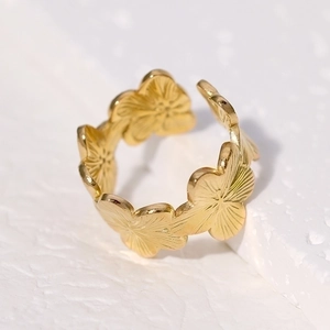 Elegant gold flower ring with stacked petal design on a white stone background
