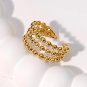 Minimalist gold stainless steel ring with three rows of beads on a white wavy base