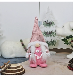 Pink Nordic gnome with sequined hat and white beard displayed among Christmas pine cones