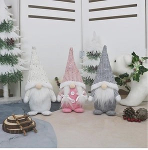 Close-up of three knitted Christmas gnomes in white, pink and grey with plush textures