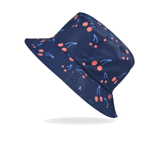 Close-up of dark blue bucket hat featuring vibrant red cherry prints and reinforced stitching