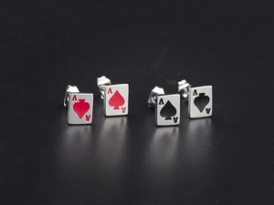 Macro shot of silver titanium steel poker ace earrings with red and black heart details