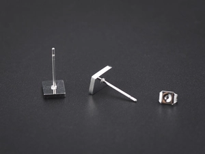 Macro shot of silver poker card stud earring showing secure butterfly backing and steel post