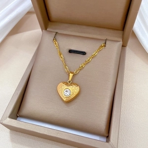 Elegant gold titanium steel heart pendant necklace with clear gem in a jewelry box
