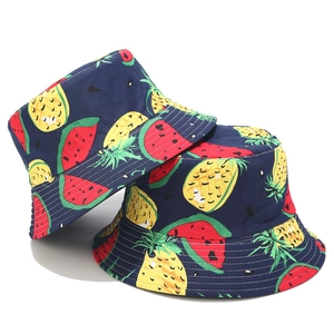 Close-up of navy bucket hat featuring vibrant watermelon and pineapple fruit patterns