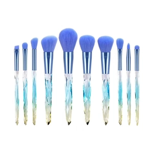 Detailed row of 11 blue crystal makeup brushes with gradient handles on white background