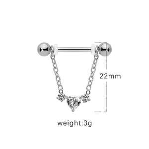 Macro shot of silver heart pendant chain nipple ring body piercing jewelry details
