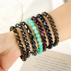 Macro shot of colorful tiger eye and volcanic stone beaded bracelets on a model wrist