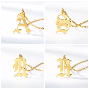 Detailed view of four golden gothic letter pendants A S R H with delicate chain