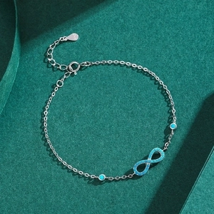 S925 sterling silver infinity bracelet with turquoise stones on dark green background
