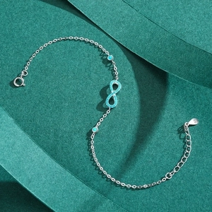 S925 sterling silver infinity symbol bracelet with turquoise beads on green background