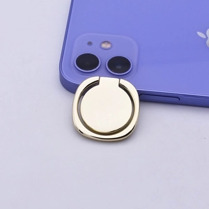 Close-up of a golden metal ring phone holder attached to a purple smartphone's back