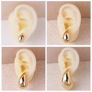 Polished gold teardrop earrings in four sizes shown on model for minimalist style