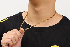 Detailed close-up of a gold stainless steel O-chain necklace on a male model neckline