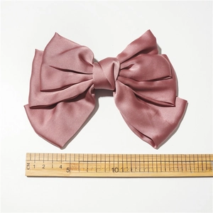 Detail of multi-layer satin bow hair clip in dusty pink with 21cm width measurement