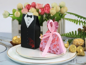Detail von Hochzeits-Gastgeschenken im Smoking- und Blumenkleid-Stil mit rosa Seidenband