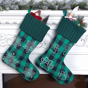 Set of two green and black plaid Christmas stockings with snowflake and paw print embroidery