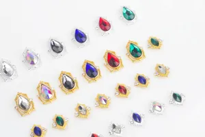Detailed view of teardrop nail charms with colorful crystals and micro-inlaid rhinestones