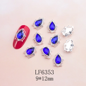 Macro detail of 9x12mm teardrop crystal nail charm with micro-pave silver bezel setting