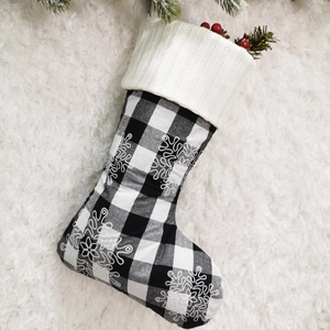Detail of black and white buffalo plaid Christmas stocking with snowflake embroidery