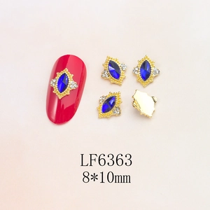 Detail view of 8x10mm gold alloy nail charms with blue horse-eye zircon and small rhinestones