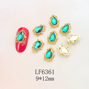Detail of 9x12mm gold alloy nail art charm with green teardrop crystal and white rhinestones
