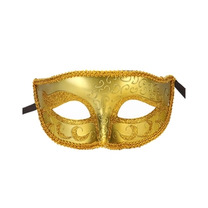 Close-up of a vintage gold masquerade mask with glitter details and black ribbons