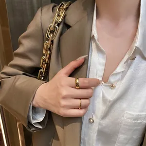 Détail de bagues minimalistes plaquées or 18 carats portées avec un fini métallique lisse