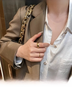 Detail of 18K gold plated minimalist rings worn on fingers with a sleek metallic finish