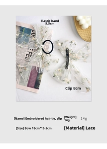 Detailed view of white floral lace bow clip and scrunchie set with delicate embroidery