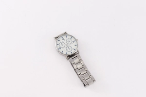 Detail shot of a silver metal multi-function watch with a white dial and steel bracelet