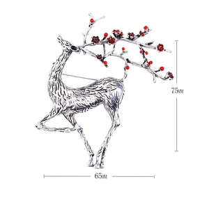Silver reindeer brooch with red berries decoration, size 65mm x 75mm on white background