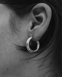 Close-up of polished S925 sterling silver C-shape hoop earring on a model ear