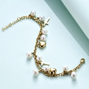 Detailed shot of golden stainless steel chain with pearls, heart, and cross charms