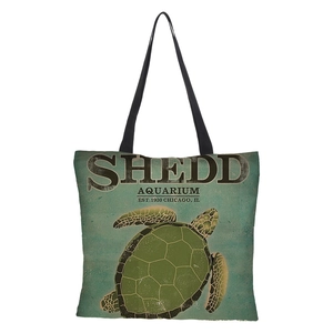 Detail view of the 3D sea turtle print and black text on this linen tote shopping bag