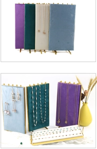 Detailed view of luxury velvet jewelry display stands with gold metal frames and hooks