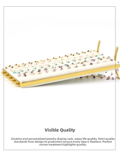 Detail of golden metal jewelry rack with white velvet lining displaying stone necklaces